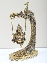 Brass Lord Ganesha figurine on peacock-design swing with hanging chain supports