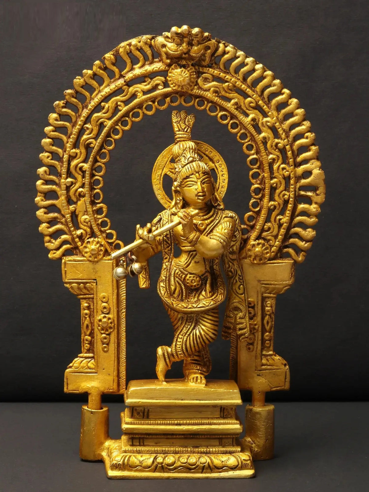 AONA brass Krishna playing flute idol on ornate kirtimukha pedestal, 8 inch