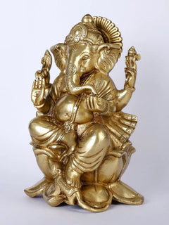 Lord Ganpati Ji idol seated on lotus, golden finish, side view with raised palms