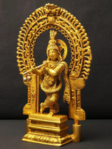 Krishna brass idol playing flute, standing on pedestal with kirtimukha arch