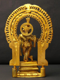 Brass Krishna idol with flute, viewed from behind on kirtimukha pedestal base