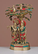 Brass Radha-Krishna idol under ornate tree with green and red inlay, 19-inch