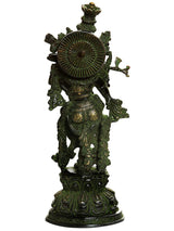 Handmade brass Krishna statue from back, arched wheel and ornate backplate, dark green.