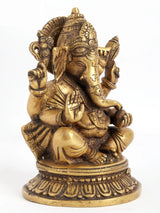 Brass Ganesha statue seated with four arms, detailed jewelry and crown, 8 inches