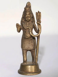 Small brass Lord Shiva statue with raised hands and trident staff, standing on base