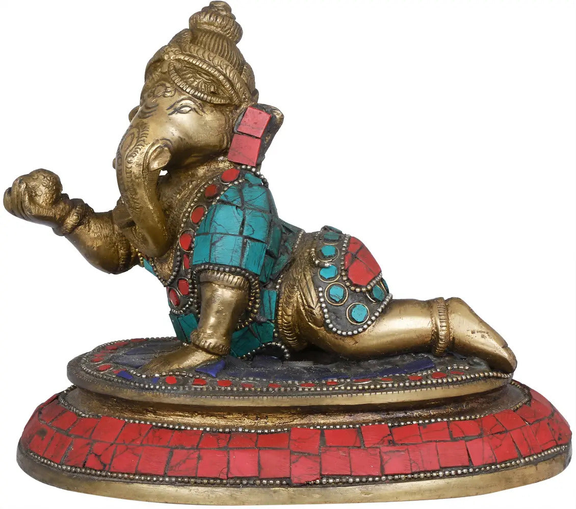 Brass Ganesha idol with turquoise and red jeweled inlay, seated on lotus base