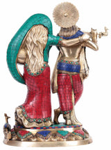 Radha Krishna brass statue, rear angle with teal hood and red patterned garment panels.