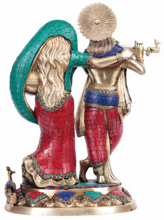 Radha Krishna brass statue, rear angle with teal hood and red patterned garment panels.
