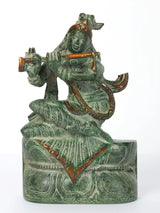 Krishna idol seated playing flute on pedestal, green patina, 7-inch figurine