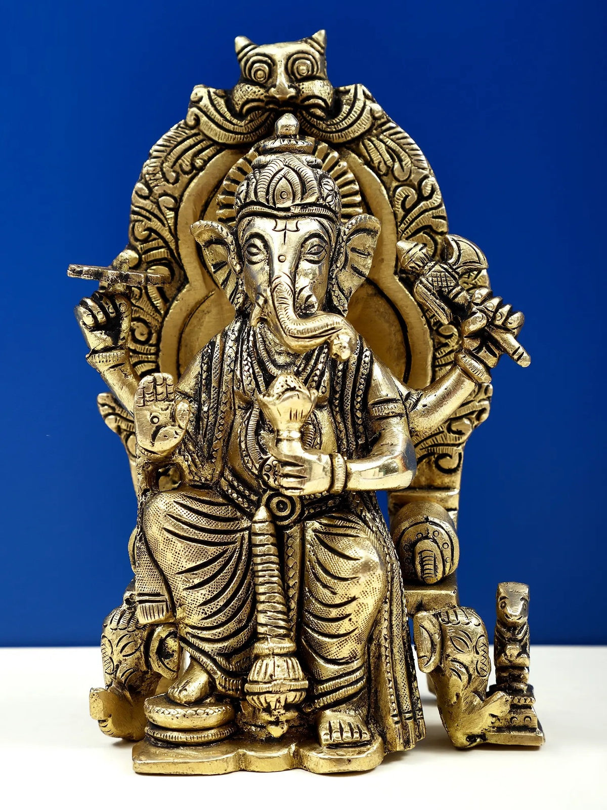 Brass 6-inch Ganesha sculpture, enthroned with ornate crown and halo