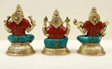 Brass idol trio view: three seated deities with red garments, teal mosaic seat, ornate details
