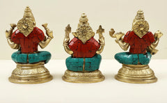 Brass idol trio view: three seated deities with red garments, teal mosaic seat, ornate details
