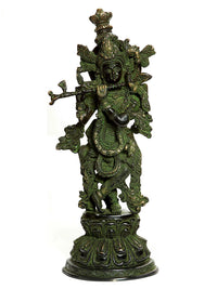 Handmade brass Krishna statue with fluting deity details, dark green patina finish.
