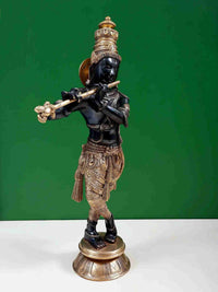 Shri Krishna brass statue holding flute horizontally, ornate crown and patterned dhoti