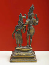 Brass Shiva and Parvati deity statue with detailed outfits and raised hands on base