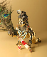 Brass Laddu Gopal idol with crown, blue and red bead necklaces, peacock feather