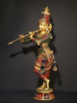 Standing Krishna brass statue holding flute, ornate red-green inlay on outfit