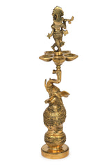 Brass Krishna and elephant lamp with three-dish flame holder, ornate detailing