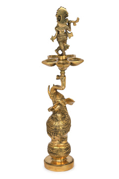 Brass Krishna and elephant lamp with three-dish flame holder, ornate detailing