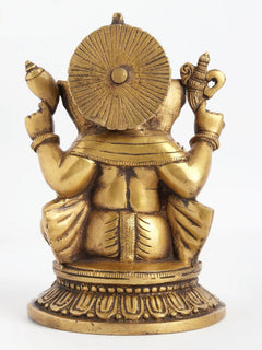 Back view of brass four-armed seated Ganesha statue with haloed back disk