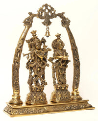 AONA brass Radha Krishna statue on base with detailed figures under arched canopy