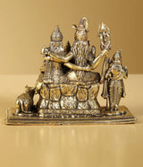 Brass Shiva family idol side view, 4-inch, seated figure holding trident and staff