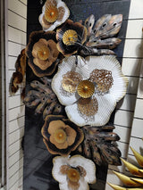 AONA iron wall decor with white scalloped flower, gold center, and dark leaf petals