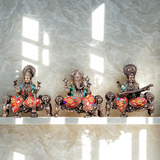 Brass idol trio—Ganesha center with Lakshmi and Saraswati, ornate painted thrones