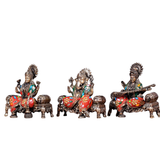 Brass Ganesha, Lakshmi, and Saraswati idols seated on decorated circular thrones