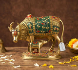 Brass cow and calf sculpture with green inlay, red details, ornamental motifs