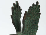 Green eagle sculpture with detailed feather texture and outstretched wings, brass patina finish