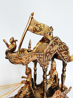 Ornate brass horse chariot sculpture with tall flag pole, riders, and wooden base