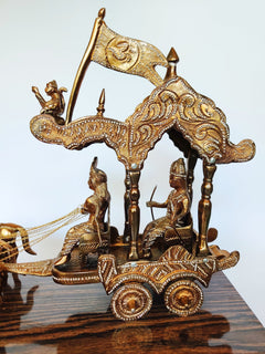 Ornate brass chariot sculpture with two riders and banner flag on wooden base