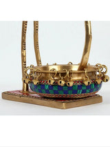 Brass urli bowl with linked chain and colorful painted band around the rim