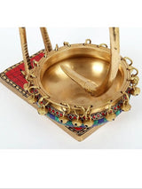 Top view of brass urli bowl inside with chain handles and colorful rim border