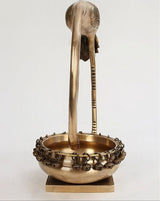 Brass flamingo urli view from side: ribbed legs and bell-like chain rim