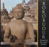 Dark stone Buddha statue with closed eyes and raised hands at the pyramid