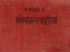 लाल कपड़े पर गीता का शीर्षक प्रिंट, क्लोज़-अप