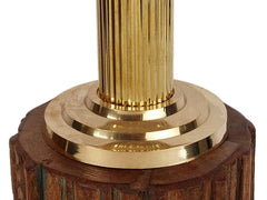 Brass and dark wooden base of the Ashoka stambh with stacked metal bands