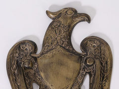 Close-up of vintage brass eagle door knocker face and wing details