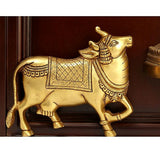 Gold-toned decorative cow figure wall ornament with patterned saddle, in wooden frame