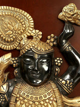 Brass deity wall hanging close-up of black face, gold crown, and raised decorative discs