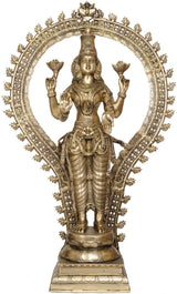 Brass Lakshmi statue with ornate halo and bejeweled draped outfit, standing on pedestal