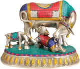 Brass Krishna drinking milk idol with decorated cow and calf on teal base