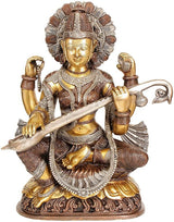 Brass statue of Goddess Saraswati seated, holding veena, ornate crown and jewelry