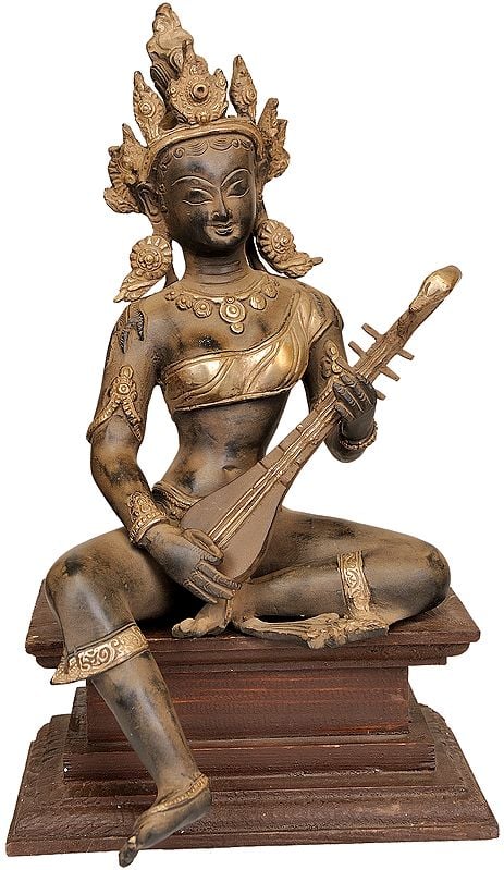 Brass Saraswati figurine seated on wooden pedestal with veena, 13 in