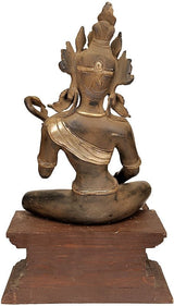 Brass Saraswati statue seated on wooden base, ornate crown and veena details