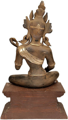 Brass Saraswati statue seated on wooden base, ornate crown and veena details