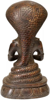 Back view of brass Patanjali sculpture with detailed cobra scales and seated base, 8 in.