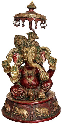 Large brass Lord Ganesha idol with umbrella, red accents, seated pose, ornate base